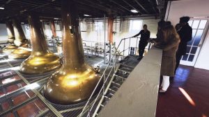 People taking a tour at Walsh Distillery to learn about whisky investment.