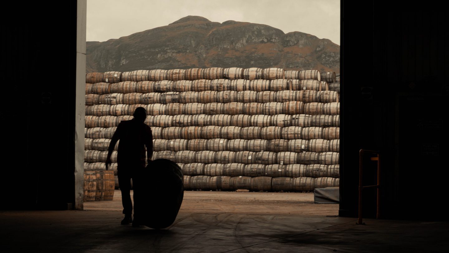 man stacking whiskey casks for investment